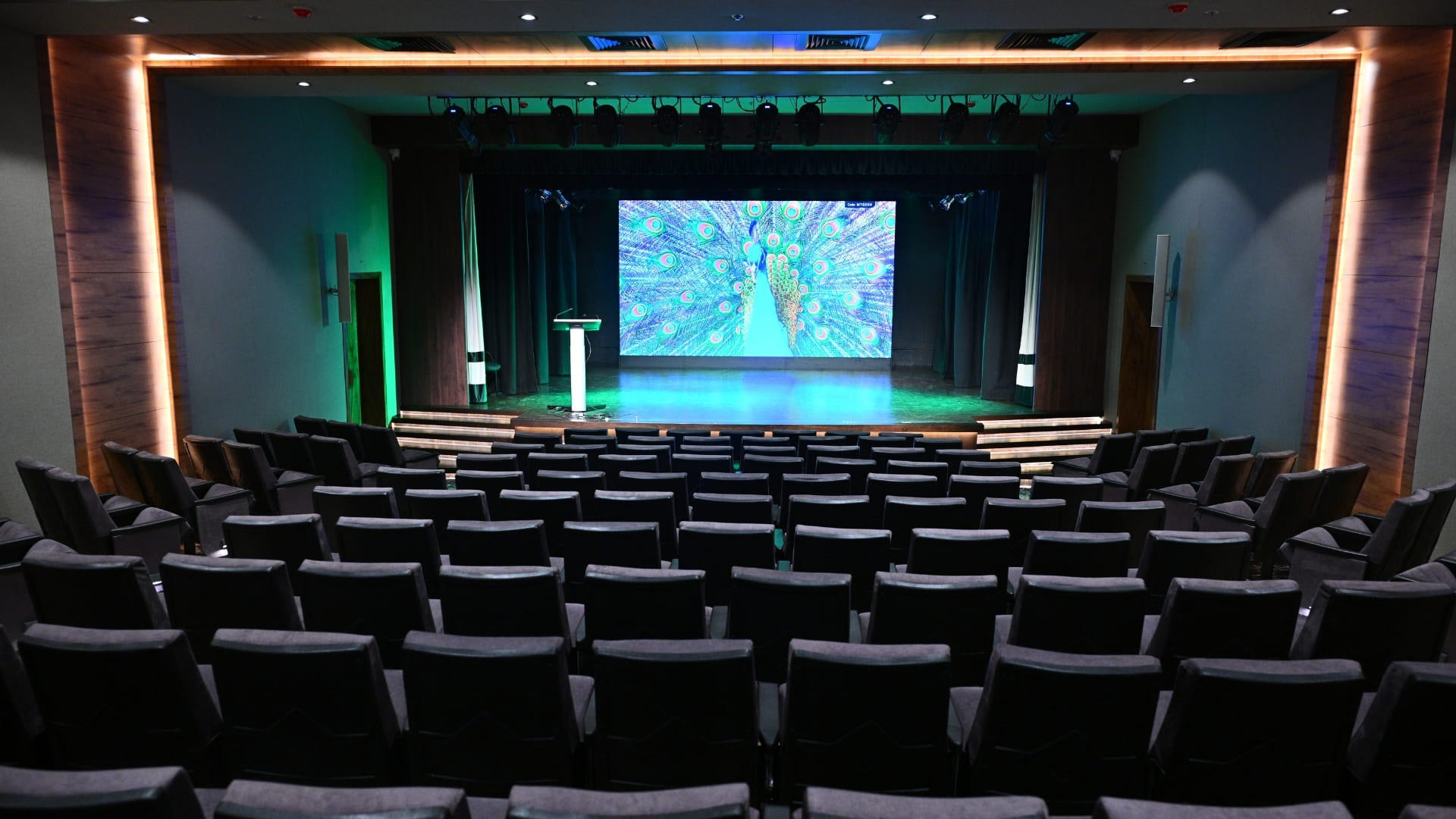 Close-up of a white d&b audiotechnik 24C cardioid column loudspeaker mounted on the auditorium wall.