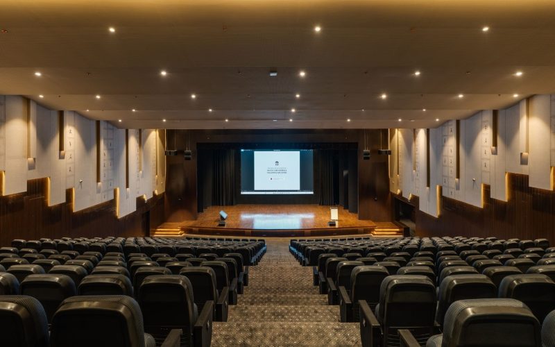 Interior of the 500-seater auditorium at Bagchi Karunashraya featuring Unilumin LED wall and acoustic wall treatments.