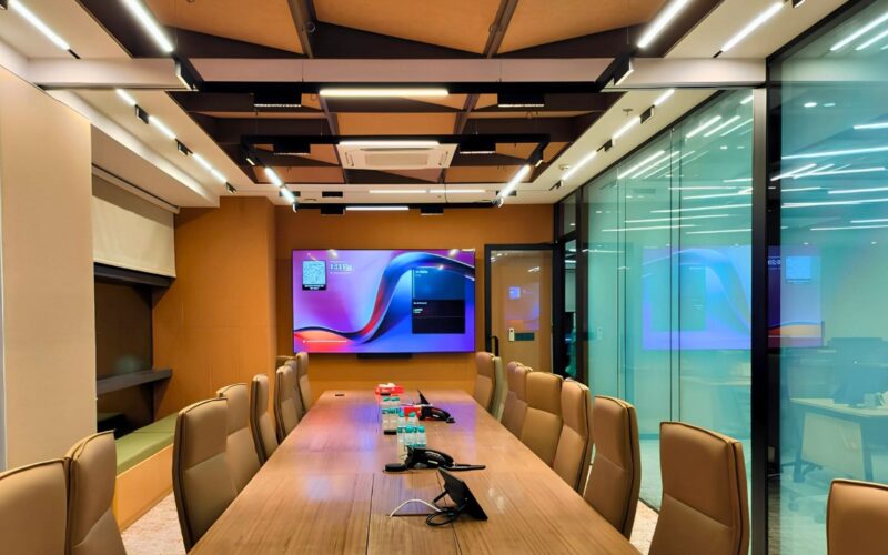 Divisible executive boardroom featuring Yealink AVHub, AI tracking cameras, and dual display collaboration.